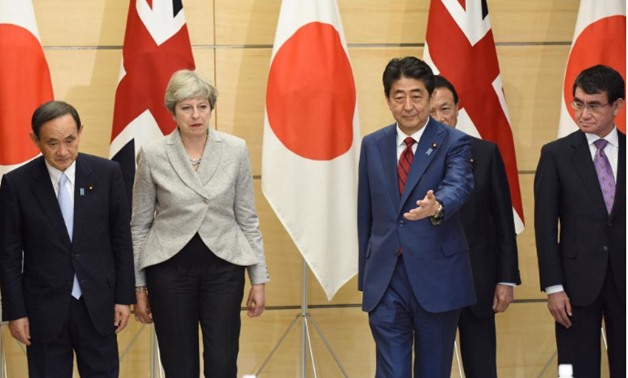 British Prime Minister Theresa May (2nd L) is greeted by Japanese Prime Minister Shinzo Abe (3rd R) as Chief Cabinet Secretary Yoshihide Suga (L), Deputy Prime Minister and Finance Minister Taro Aso (2nd R), and Foreign Minister Taro Kono (R) look on