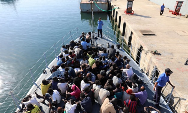Migrants in a boat arrive at a naval base after they were rescued by Libyan coastguard, in Tripoli - REUTERS
