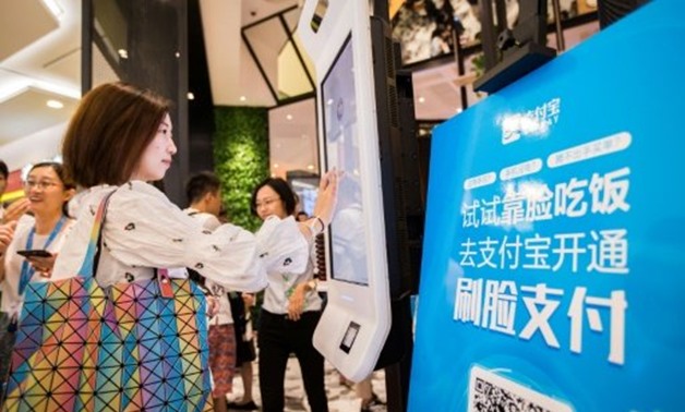 A customer tries out a facial recognition payment system at a KFC fast food restaurant in Hangzhou, China