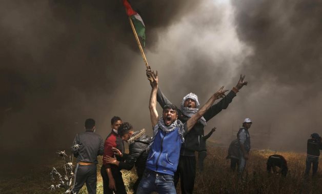 Palestinian demonstrators shout during clashes with Israeli troops at a protest demanding the right to return to their homeland, at the Israel-Gaza border east of Gaza City, April 6, 2018. REUTERS