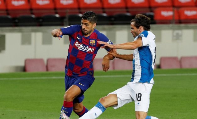 July 8, 2020 Barcelona's Luis Suarez in action with Espanyol's Leandro Cabrera, as play resumes behind closed doors following the outbreak of the coronavirus disease (COVID-19) REUTERS/Albert Gea