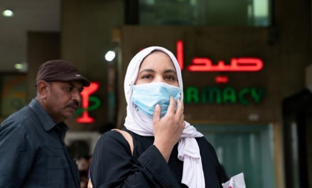 FILE PHOTO: A woman wears a protective face mask, following the outbreak of the new coronavirus, in Kuwait, February 25, 2020. REUTERS/Stephanie McGehee/File Photo