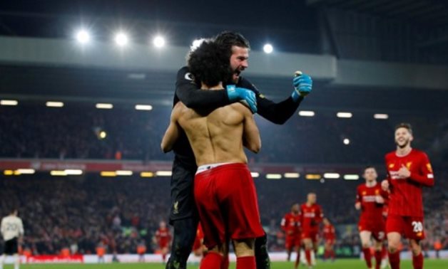 Liverpool's Mohamed Salah celebrates scoring with Alisson. -Reuters