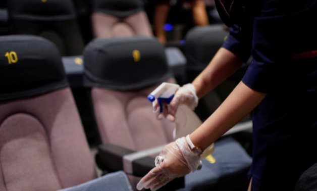A staff member disinfects seats in a cinema as it reopens following the coronavirus disease (COVID-19) outbreak, in Shanghai, China July 20, 2020. REUTERS/Aly Song