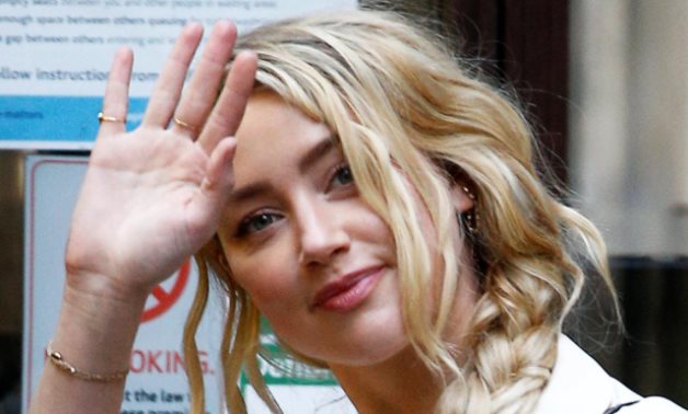 FILE PHOTO: Actor Amber Heard waves as she arrives at the High Court in London, Britain July 20, 2020. REUTERS/Henry Nicholls