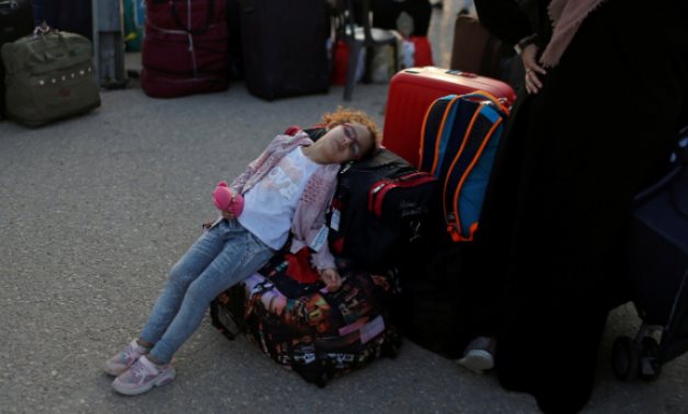 A girl rests as she waits before leaving the Palestinian Rafah border crossing with Egypt, August 12, 2020. REUTERS/Mohammed Salem