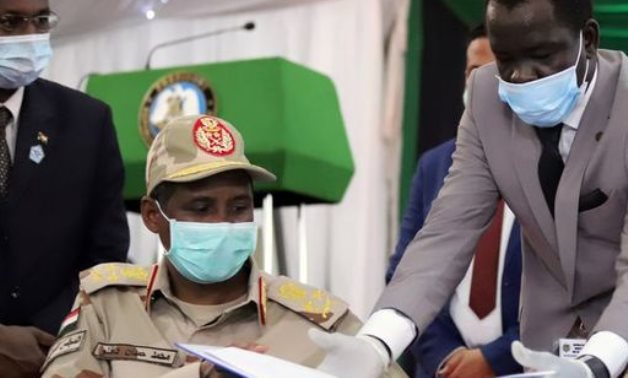 Lieutenant General Mohamed Hamdan Dagalo, deputy head of the military council and head of the RSF, reveives a peace agreement to sign between Sudan's power-sharing government and five key rebel groups - Reuters