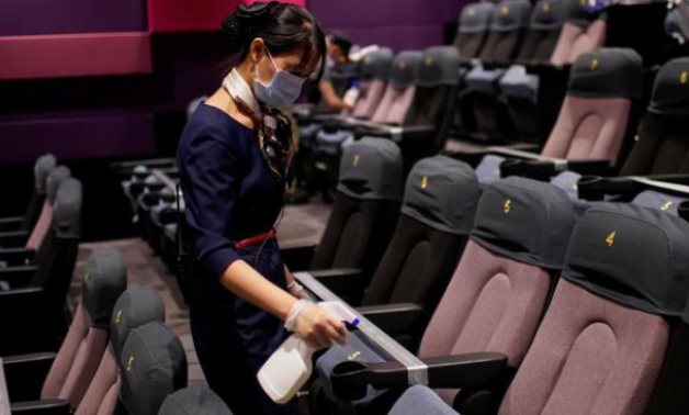 A staff member wearing a face mask disinfects seats in a cinema as it reopens following the coronavirus disease (COVID-19) outbreak, in Shanghai, China July 20, 2020. REUTERS/Aly Song