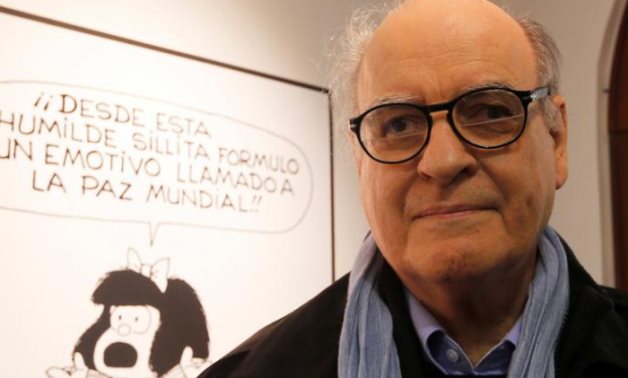 FILE PHOTO: Argentine cartoonist Joaquin Lavado, also known by his pen name Quino, poses in front of an image of his most famous comic character Mafalda REUTERS/Enrique Marcarian/File Photo