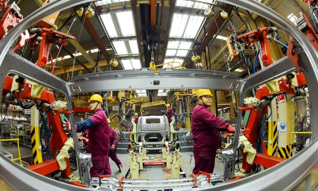 FILE PHOTO: Employees work on a production line manufacturing light trucks at a JAC Motors plant in Weifang, Shandong province, China November 30, 2018. REUTERS/Stringer/File Photo