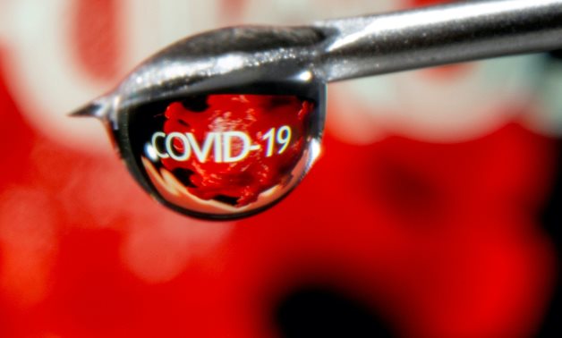 FILE PHOTO: The word "COVID-19" is reflected in a drop on a syringe needle in this illustration taken November 9, 2020. REUTERS/Dado Ruvic/Illustration/File Photo