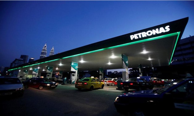Motorists queue to fill natural gas at a Petronas station with its landmark Petronas Twin Towers headquarters in the background, in Kuala Lumpur February 4, 2012. REUTERS/Bazuki Muhammad/File Photo