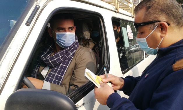 Officer checks the driving license of a driver in Cairo Jan. 3, 2021 - Youm7
