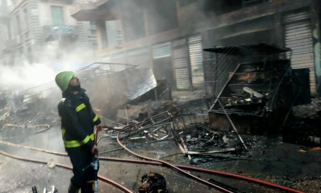 A firefighter deals with a huge fire broke out through shops and buildings in Tawfiqia market – Cairo governorate