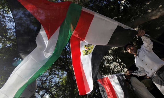 An Egyptian holds Egyptian and Palestinian flags in Cairo, Egypt, Nov. 15, 2012. Photo by REUTERS/Amr Abdallah Dalsh