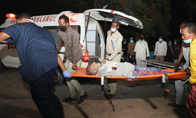 People assist an injured person outside Madina Hospital after a blast at the Luul Yemeni restaurant near the port in Mogadishu, Somalia March 5, 2021. REUTERS/Feisal Omar