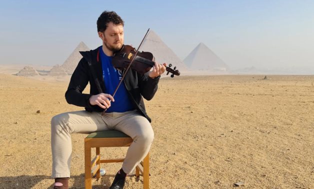 Irish musician Micheál Ó HIarlaithe in front of the Giza Pyramids - Min. of Tourism & Antiquities