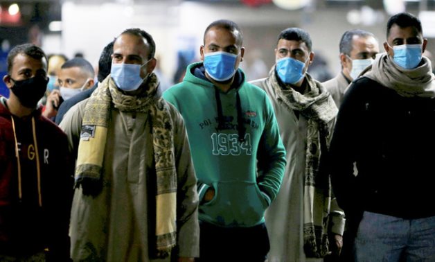 Men in protective masks wait for the train at a metro station in Cairo. (Reuters)