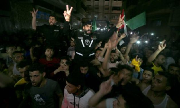 Palestinians celebrate in the streets following a ceasefire, in the southern Gaza Strip May 21, 2021. Reuters