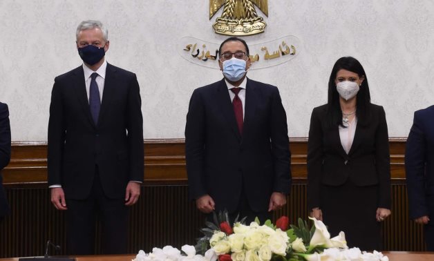 Prime Minister Mustafa Madbouli (M) with Egyptian Minister of International Cooperation Rania El Mashat (R) and French Finance Minister Bruno Le Maire (L) pose for a picture, June 13, 2021- press photo.