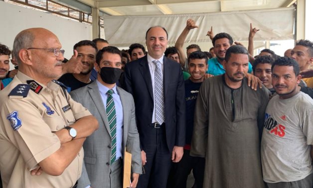 Egyptian Ambassador to Libya Mohamed Tharwat Selim posing with Egyptians freed from illegal migration center in Tripoli on June 21, 2021. Press Photo 