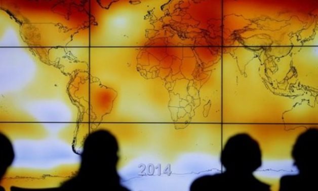 Participants are seen in silhouette as they look at a screen showing a world map with climate anomalies during World Climate Change Conference 2015 at Le Bourget, near Paris, France, December 8, 2015. REUTERS