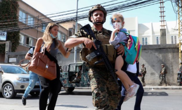 Lebanese soldier carrying a schoolgirl after the shooting - Mohamed Azakir/Reuters