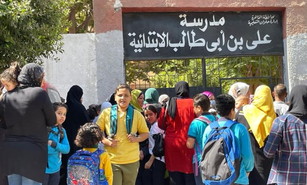 Students and some mothers are waiting outside Ali bin Abi Taleb primary school in Helwan, southern Cairo- Egypt Today/ Samar Samir