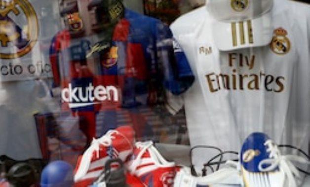 Barcelona, Real Madrid and Atletico Madrid merchandise is seen through a shop window. REUTERS/Susana Vera