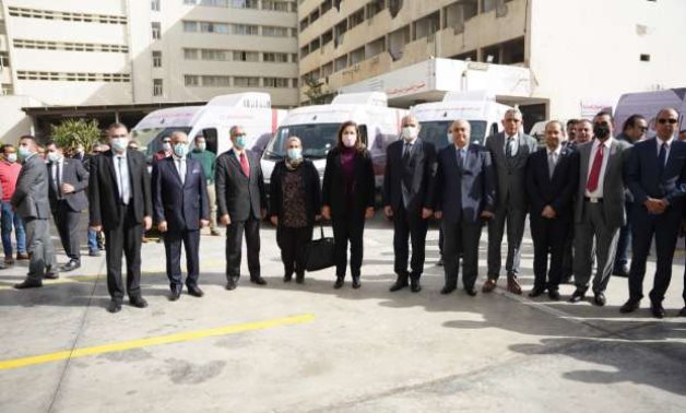 Minister of Planning and Economic Development Hala al-Said posing with other officials in front of civil service vehicles on December 9, 2021. Press Photo