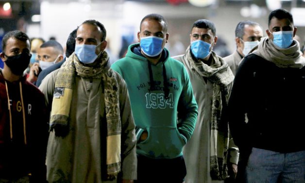 Men in protective masks wait for the train at a metro station in Cairo. (Reuters)