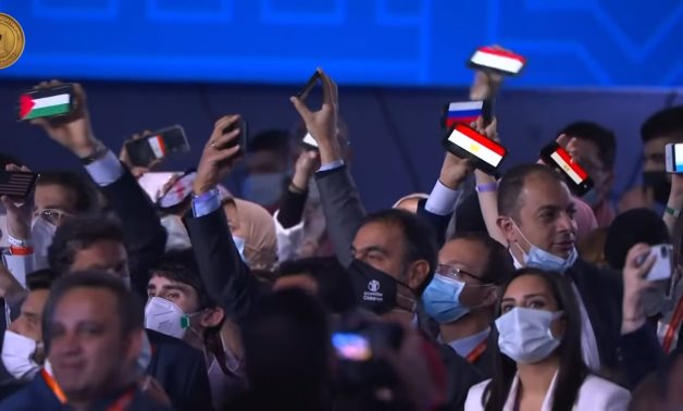 A number of young people raising the flags of their countries during the opening session of the World Youth Forum's fourth edition in Sharm El-Sheikh city - Egyptian Presidency/screenshot