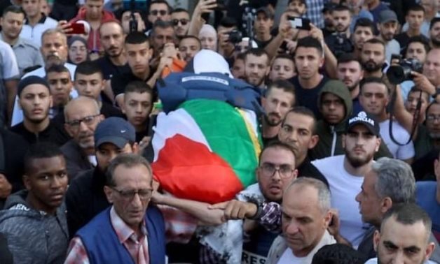 The remains of the journalist Shireen Abu Akleh were carried through the streets of Jenin after she was fatally shot while reporting amid a raid by Israeli forces in the West Bank city.