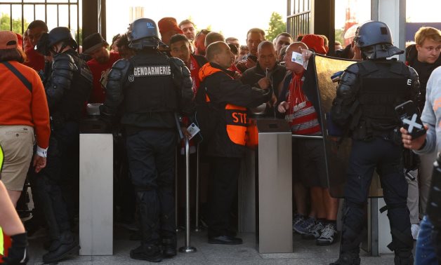 Fans, stewards and police officers by the turnstiles inside the stadium as the match is delayed REUTERS/Kai Pfaffenbach
