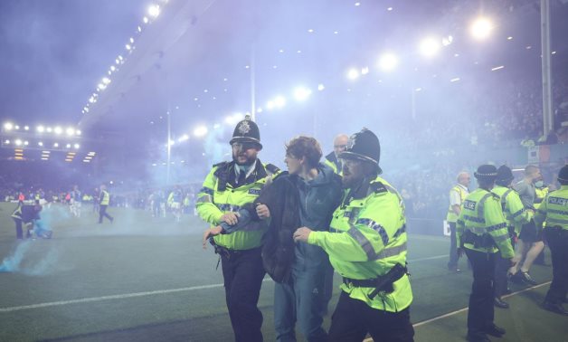 Police officer detain Everton fans as they celebrate avoiding relegation from the Premier League during a pitch invasion after the match Action Images via Reuters/Carl Recine