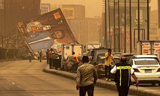 A billboard halts traffic in the 6th of October City, Giza after falling due to the sandstorm