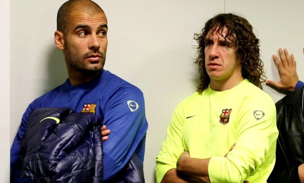 Barcelona's coach Pep Guardiola (L) gestures near captain Carles Puyol in the news room after a training session at Ciutat deportiva Joan Gamper. REUTERS/Gustau Nacarino (SPAIN SPORT SOCCER)/File Photo