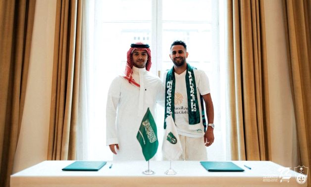 Al-Ahli's new signing Riyad Mahrez poses for a photograph with Al-Ahli executive director Yazin Al-Sharif Al-Ahli Club Media Office/Handout via REUTERS