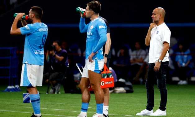 Manchester City manager Pep Guardiola looks on as Manchester City's Mateo Kovacic and Jack Grealish take a drink REUTERS/Kim Kyung-Hoon/File Photo