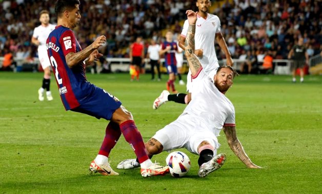 FC Barcelona's Joao Cancelo in action with Sevilla's Sergio Ramos REUTERS/Albert Gea