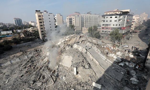 Palestinians inspect the ruins of Watan Tower destroyed in Israeli airstrikes in Gaza city, on October 8, 2023 – WAFA