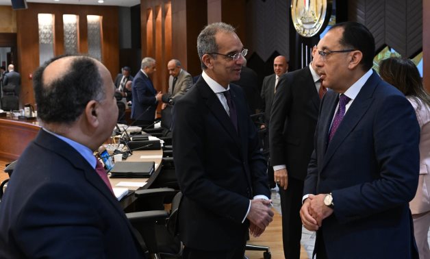 Egypt's Prime Minister Mostafa Madbouli (R) talks to Minister of Finance Mohamed Maait (left) and Minister of Communications and Information Technology Amr Talaat during the Cabinet meeting on Wednesday 