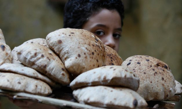 FILE - A child balancing a tray of bread on his shoulder at a bakery in Cairo – Flickr/Nasser Nouri