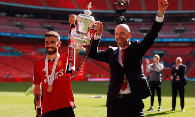 Manchester United's Bruno Fernandes and manager Erik ten Hag celebrate with the trophy after winning the FA Cup Action Images via Reuters/Andrew Couldridge