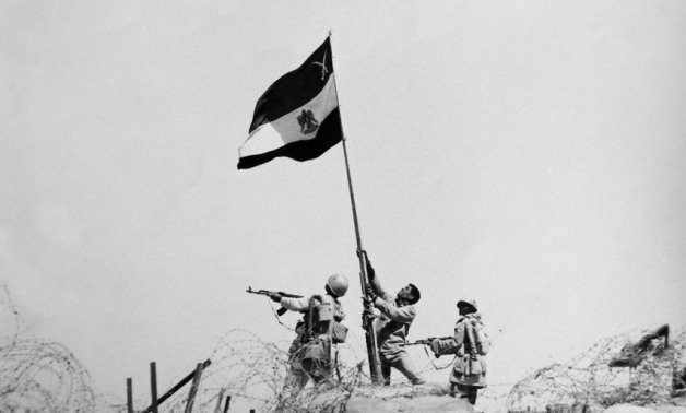 A symbolic photo shows Egyptian soldiers raising the national flag on the eastern bank of the Suez Canal during the October 6, 1973 war—a proud moment that marked a turning point in history.