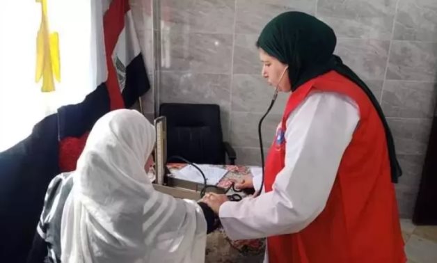 FILE - A healthcare worker measures a citizen's blood pressure as part of Egypt's presidential health initiatives