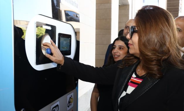 The  Minster of Envirnment and Local Development Manal Awad inserts a bottle inside a newly-arrived Reverse Vending Machines (RVM) in the Administrative Capital in Cairo- press photo