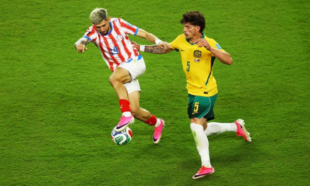 Paraguay's Julio Enciso in action with Australia's Jordan Bos REUTERS/Luisa Gonzalez 