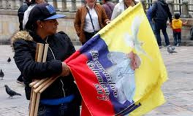 A woman sells flags with the image of Pope Francis outside the Cathedral of Bogota in Bolivar Square, Colombia September 2, 2017. REUTERS/Henry Romero