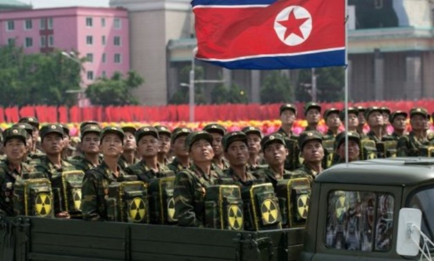 © AFP/File | North Korean soldiers carry packs marked with a radioactive symbol at a 2013 military parade in Pyongyang
